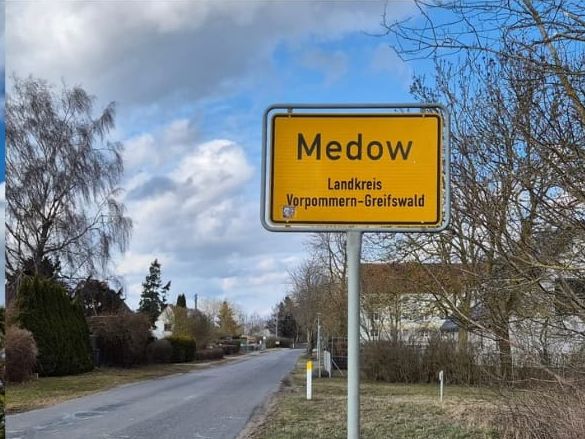 Ortseingangsschild Medow an einer Landstraße.